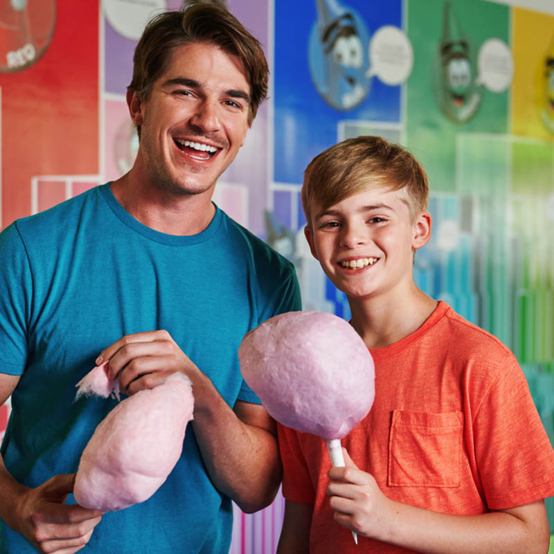 Two people holding pink cotton candy