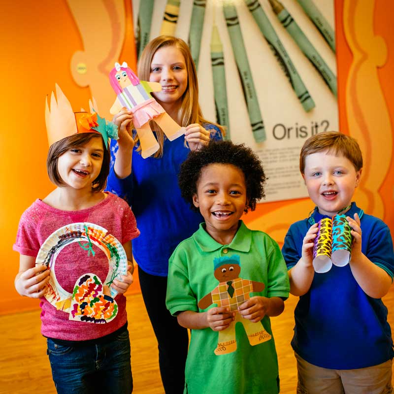Kids with various finished Crayola Experience crafts